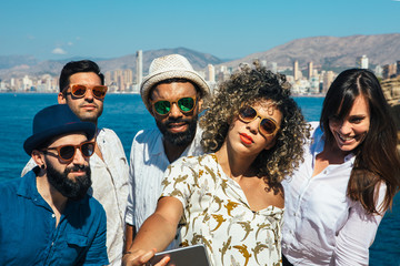 Stylish group of friends in sunglasses makes selfie