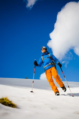 Mountain climber walks on a snowy slope.