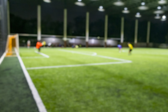 defocused of people playing soccer in the Artificial Turf soccer field