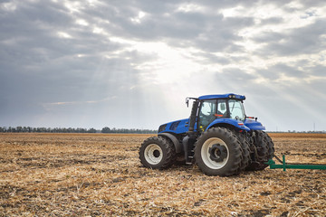 Obraz premium Tractor working in the field in autumn