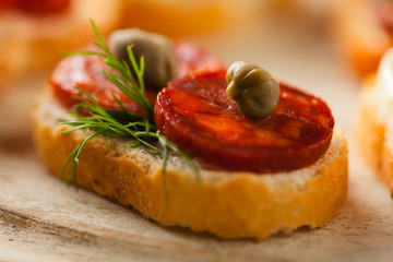 Crostini with different toppings on wooden background. Delicious appetizers. Front view.