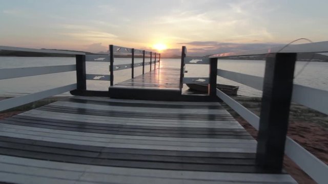 Walking on a dock at sunset, tracking shot at Imboassica lake in Macae Brazil, 