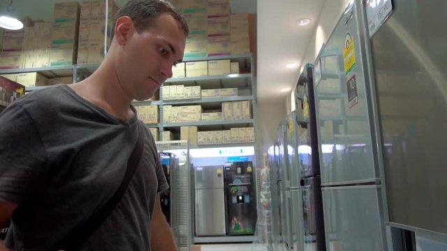 Man is buing for fridge at shopping mall