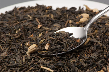 one spoon of green tea leaves close-up