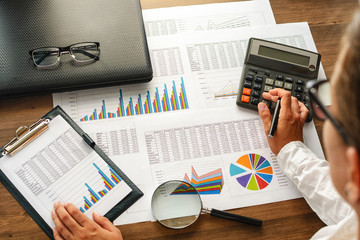 Financial paper charts and graphs on the table.
