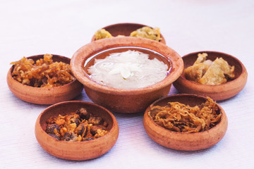 rice in ice water with side dishes such deep fried pork, onion,