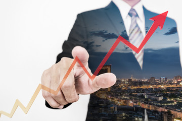Businessman drawing a rising up arrow by finger, representing business growth