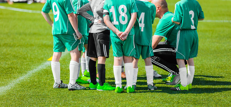Soccer coach giving young football team instructions. Youth soccer team before final game. Football; soccer match for children. Football soccer game. Motivational strategy talk for sports team - Powered by Adobe