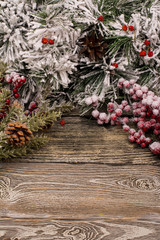 Fototapeta na wymiar Fir branch and berries in snow, cone on wooden background. Christmas theme. Template