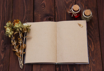 Open book with blank pages and dried herbs. Notepad with pages of kraft paper. Autumn dry flowers