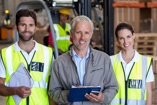 Portrait of warehouse manager and workers standing together