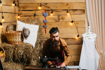 Tailor man sews clothes