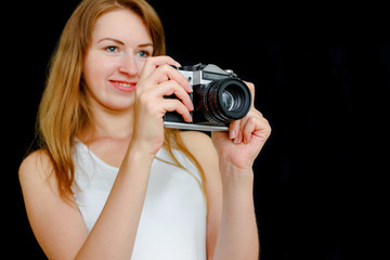 The girl photographs on the film camera