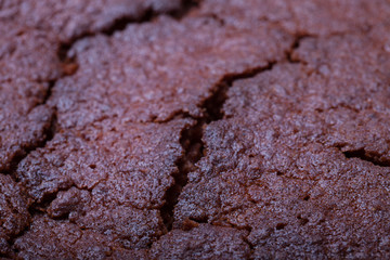 Top of fresh chocolate cake with cracks. Selective focus