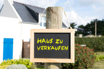Ein Schild für ein Haus zu Verkaufen