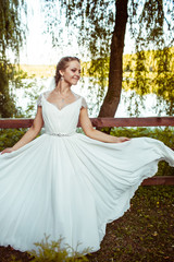 Fototapeta premium beautiful young bride standing in a green park