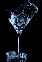 Water splash in glass with ice cubes