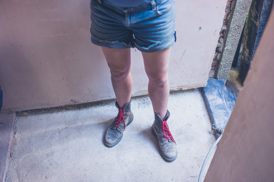 Legs of young woman by door frame
