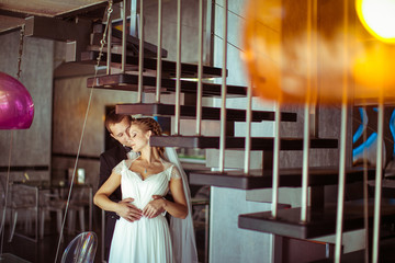 Charming happy couple standing near the stairs