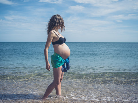 Pregnant woman in sarong on the beach