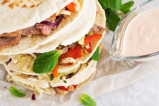 Meat pita bread with yogurt sauce and mint leaves