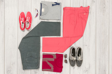 Set of men's clothing and shoes on wooden background. Sports T-shirt and sneakers in bright colors. Top view