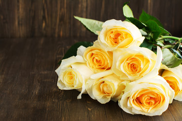 Beautiful yellow roses over grunge wooden background
