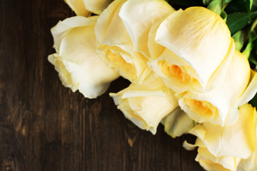 Beautiful yellow roses over grunge wooden background