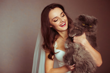 Fototapeta na wymiar Attractive young bride holds a seious fluffy cat