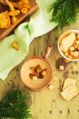 Chanterelle cream soup in coper mug served with croutons