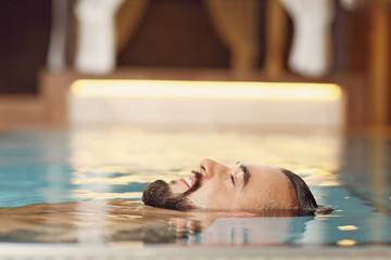 Handsome man relaxing in pool spa