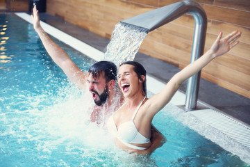 Happy couple relaxing in pool spa