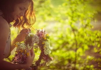 woman holding a beautiful wreath of flowers outdoors
