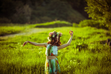 incredibly beautiful woman in a wreath walking in the garden