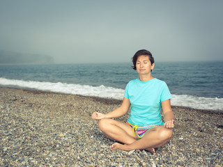 Fototapeta na wymiar Woman meditating at seaside