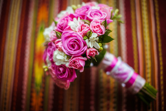 Pink roses and white flowers put in the wedding bouquer lie on t