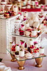 Golden vases hold a mirror tray with sweets