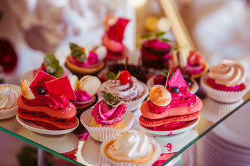 Pink macaroons stand on a mirror tray