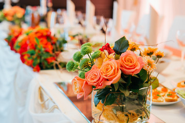 Rose buds and greenery stand in glass vases