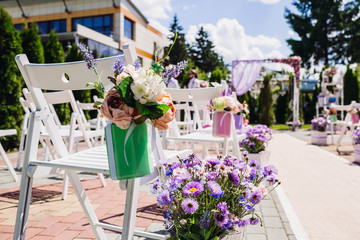 beautiful white arch and chairs with flowers for wedding ceremon