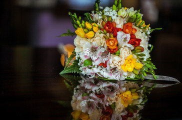 Bright wedding bouquet lies on the wooden table