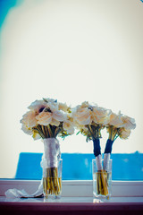 Bouquets made of white roses stand on the windowsill