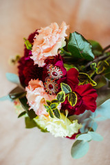 Precious earrings lie on dark red bouquet