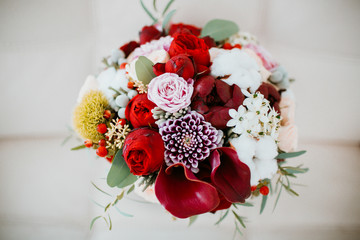 Bouquet made of dark flowers stands on the white background