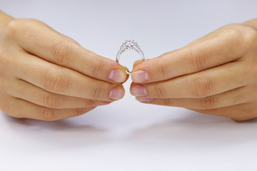 Hands holding a ring on a white background