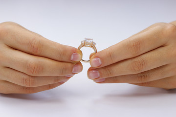 Hands holding a ring on a white background