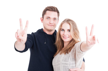 Happy handsome couple showing peace gesture