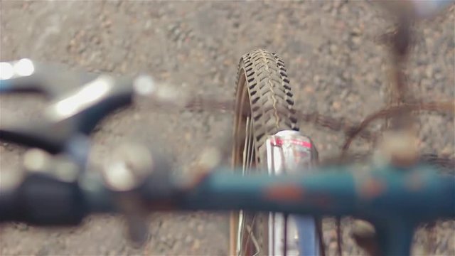 the front wheel of an old bicycle on the asphalt
