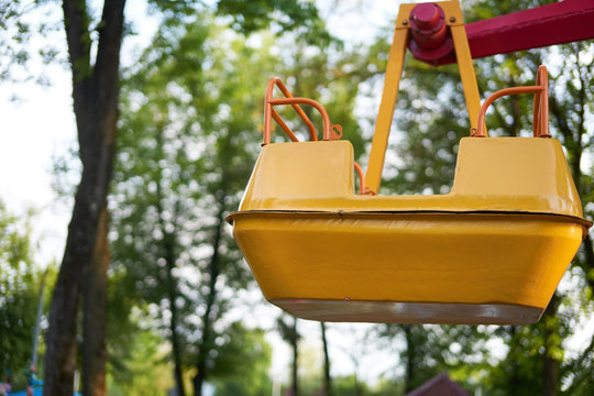The yellow empty cabin of a small ferris wheel "Sun" for young children in the russian park