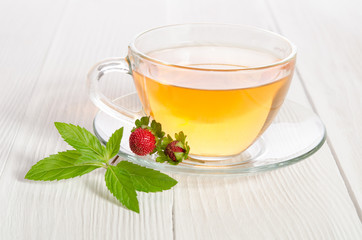 Cup of tea and strawbarries on the white wooden table